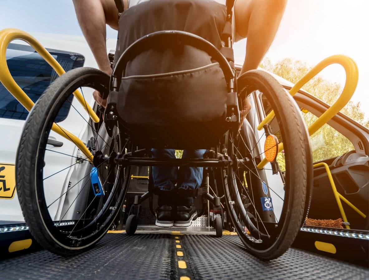 Ein Rollstuhlfahrer beim Betreten eines Taxis